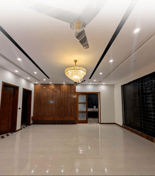 1 Kanal house for sale in IEP Town Sector A, Lahore - drawing room with chandelier and wooden feature wall