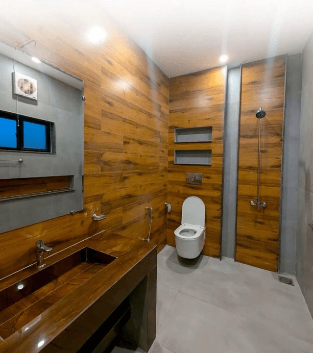 1 Kanal house for sale in IEP Town Sector A, Lahore - bathroom with wood-finish tiling and vanity